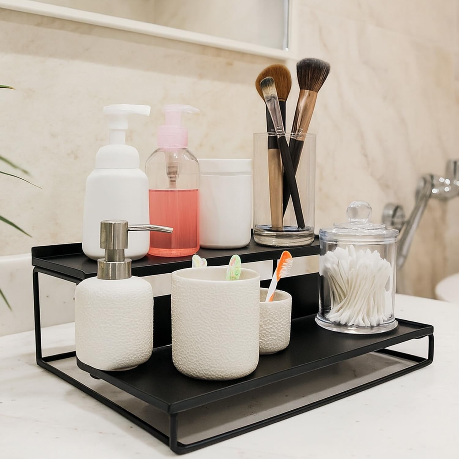 GoHooked 3-tier white metal countertop organizer shelf holding soap dispensers, cotton swabs, and makeup brushes.