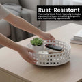 GoHooked white metal revolving bathroom organizer tray with grid pattern, holding a plant, candle, and remote.