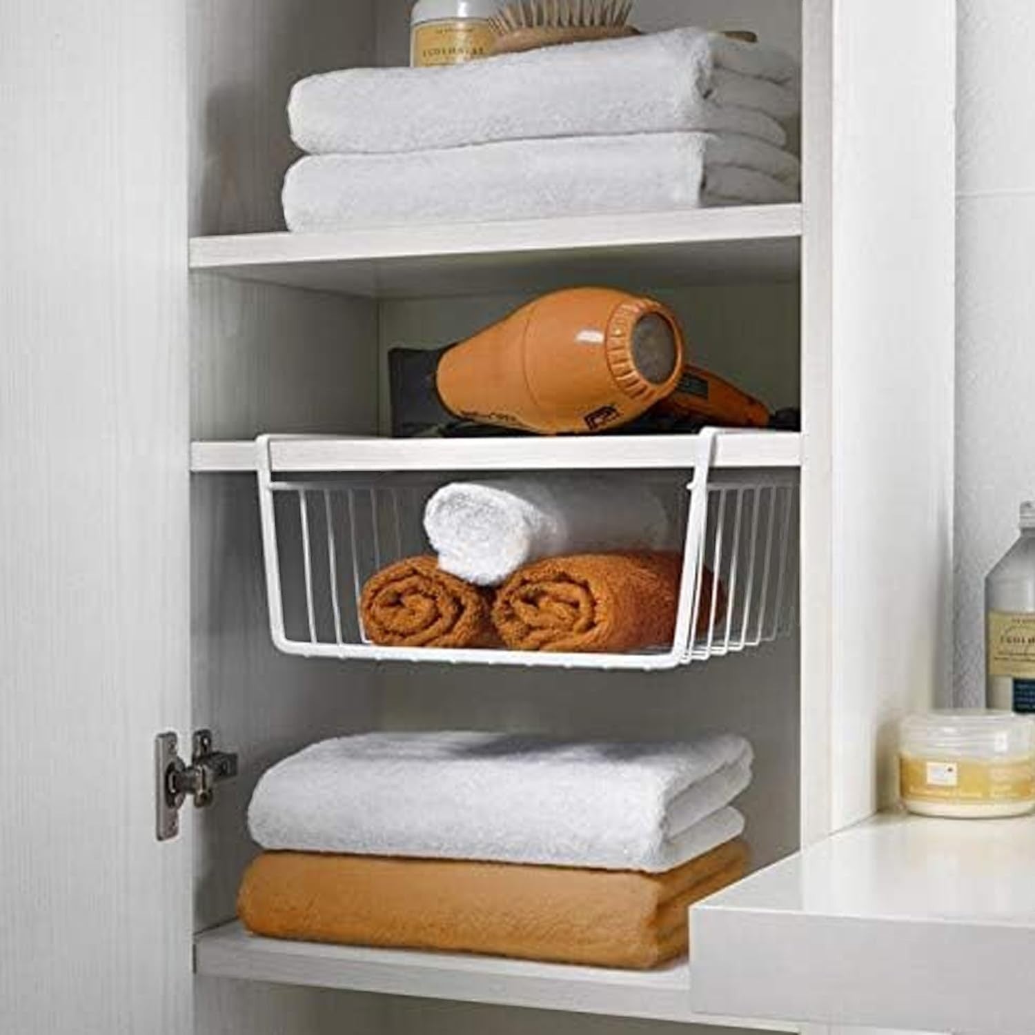 GoHooked white metal undershelf storage basket holding rolled towels in a cabinet. Pack of 2.