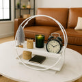 GoHooked white 2-tier metal vanity storage organizer with circular handles, holding decorative items on a coffee table.