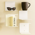 GoHooked white metal wall shelves, set of 3, displaying sunglasses, a book, and a mug. Ideal for study rooms or living rooms.