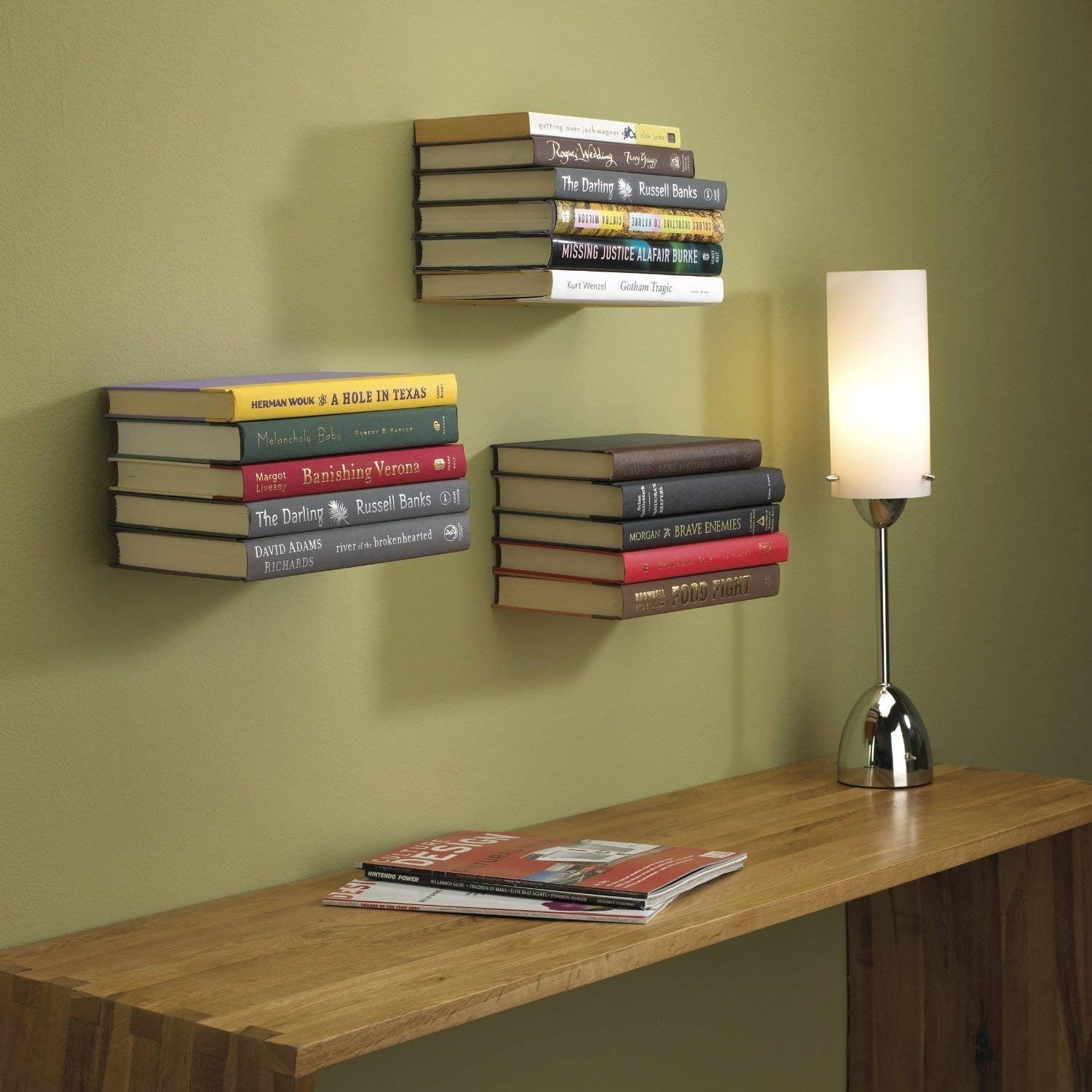 Go Hooked white heavy duty iron wall mounted book shelves, set of 3, holding stacks of books.