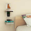 GoHooked white metal wall shelves holding books, a statue, and a vase in a bedroom setting.