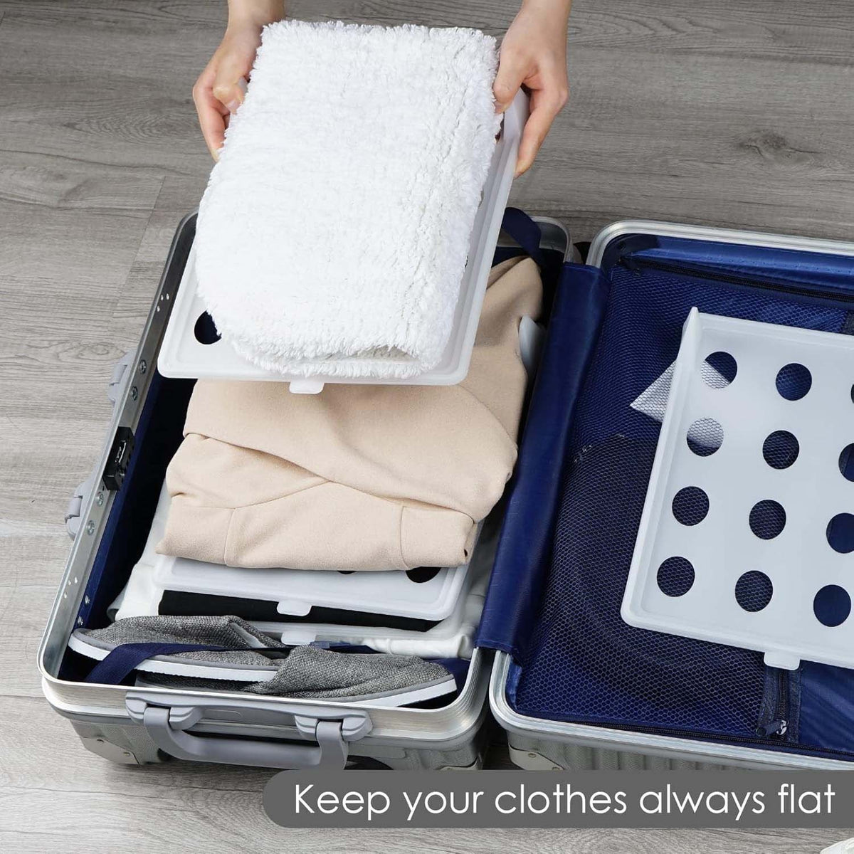 GoHooked white plastic stackable clothing organizer tray used to keep folded shirts neat inside a travel suitcase.