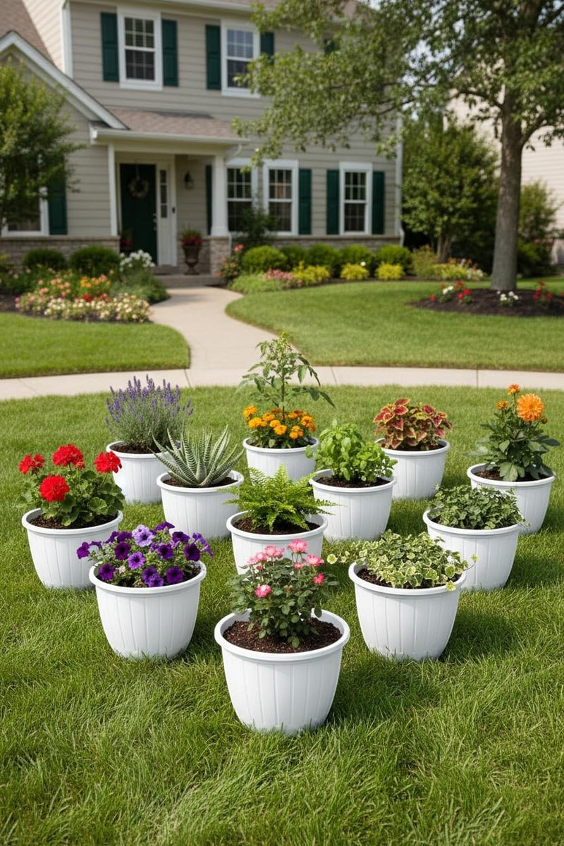 GoHooked white 10-inch plastic planters filled with various flowers and plants on a lawn in front of a house.
