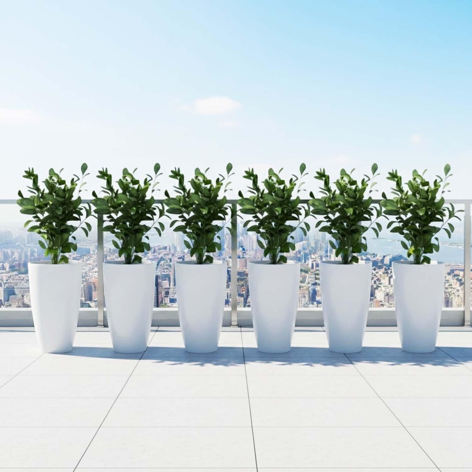 GoHooked set of 3 white plastic planters with green plants on a balcony overlooking a city skyline.