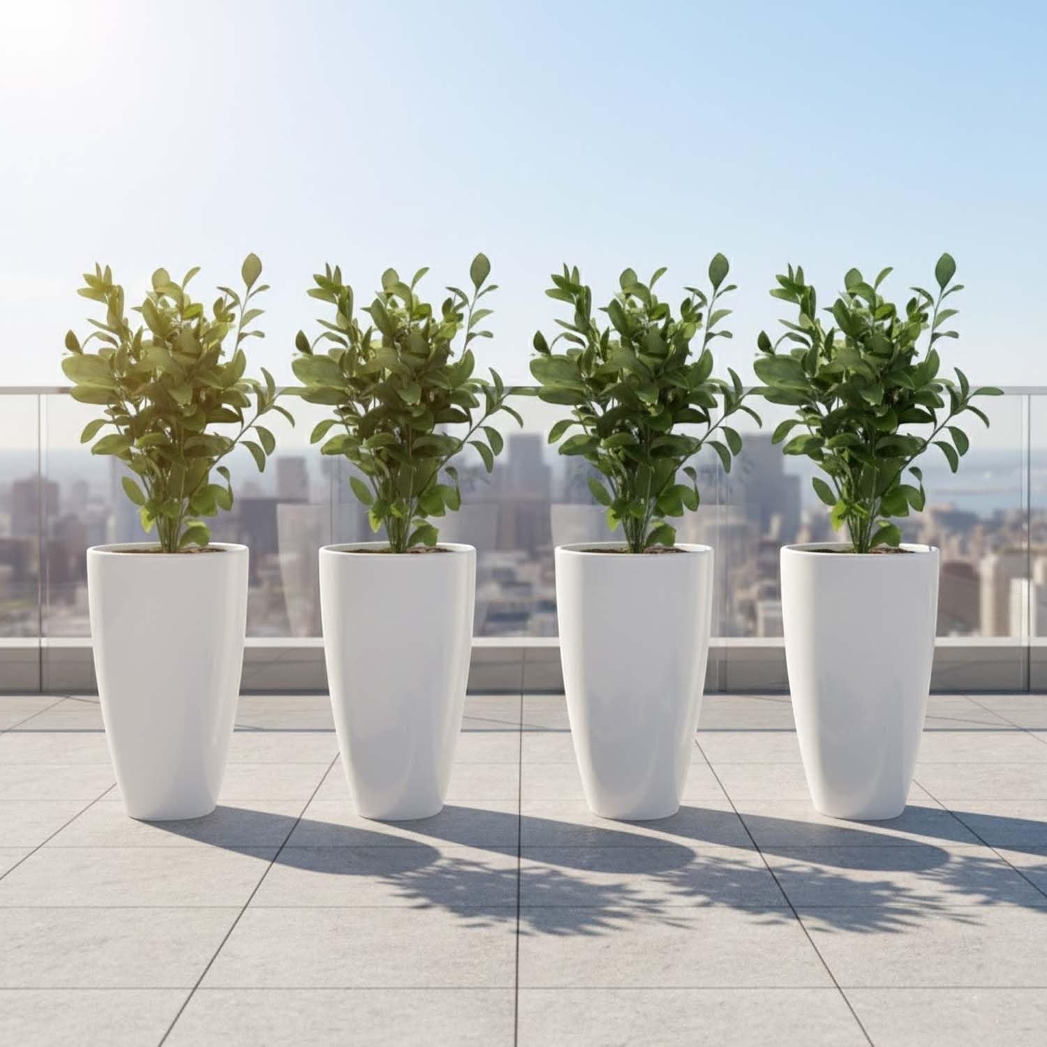 GoHooked white tapered plastic planters with green plants on a tiled balcony with city skyline.