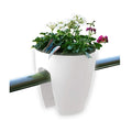 GoHooked white plastic 12-inch railing planter with white and pink flowers and a blue butterfly decoration.
