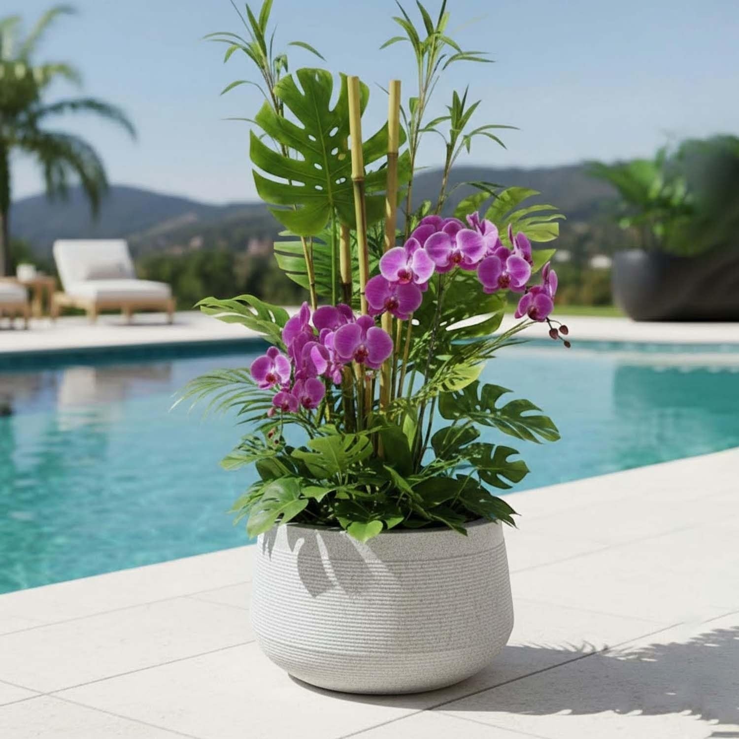 GoHooked 15 inch white textured polymer planter with purple orchids and tropical plants by a pool.