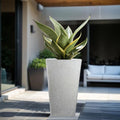 GoHooked white 18-inch tall tapered polymer planter with speckled finish, holding a snake plant on a patio.