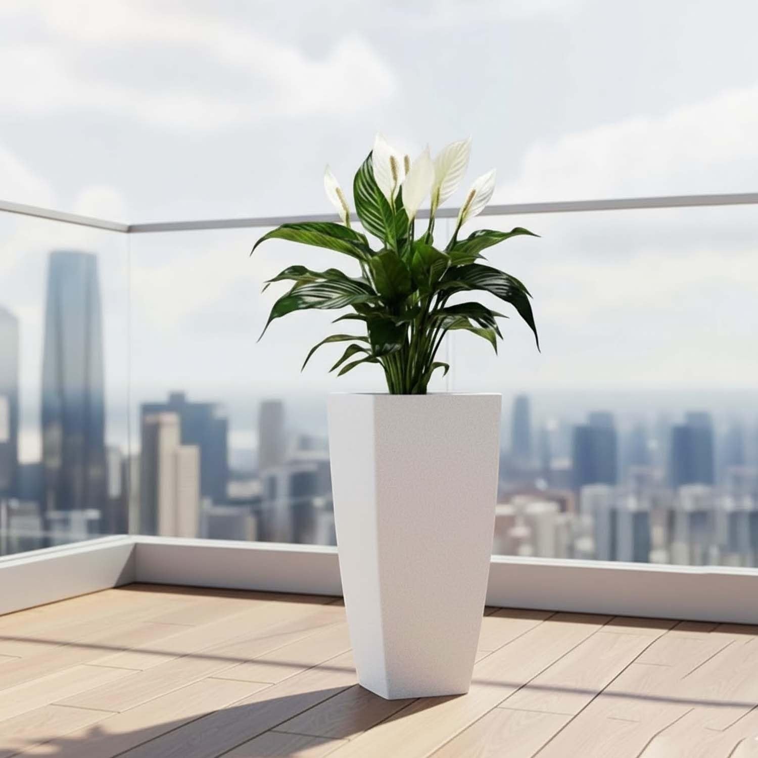 Go Hooked white polymer planter with a peace lily plant on a balcony with city view.