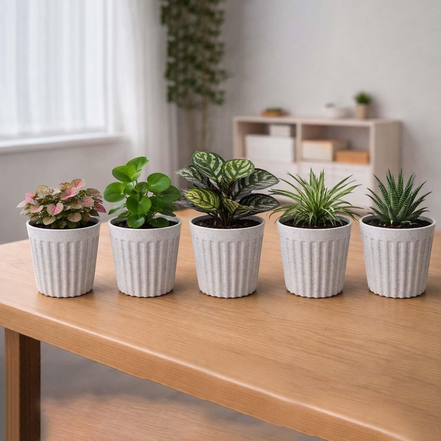 GoHooked white ribbed plastic flower pots with marble finish, holding small indoor plants on a wooden table.