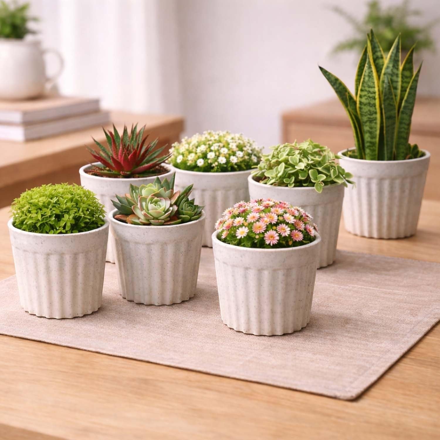 GoHooked white ribbed plastic flower pots with marble finish, holding various small plants like succulents and snake plants.