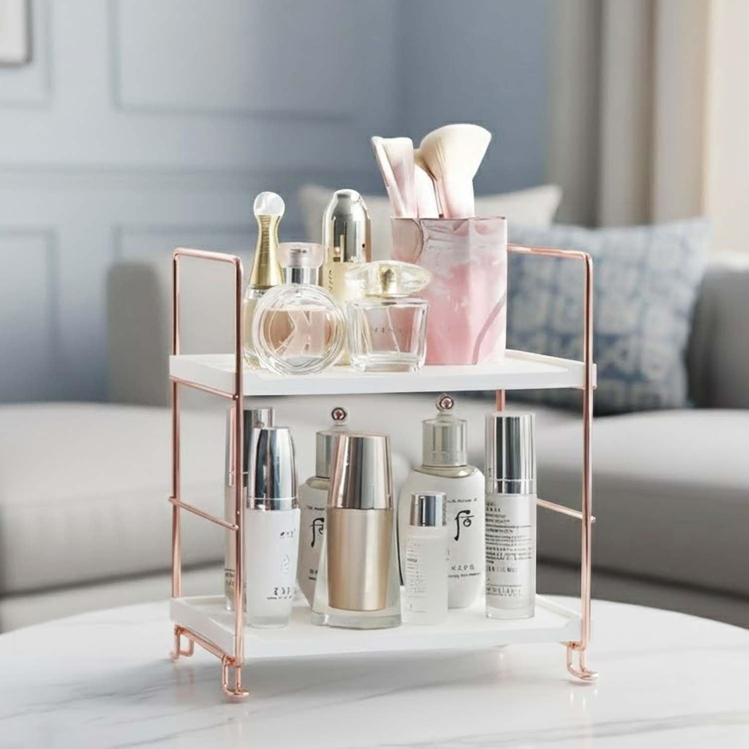 GoHooked white 2-tier metal and polypropylene shelf rack with rose gold accents, holding skincare and makeup.