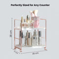 GoHooked white 2-tier shelf rack with rose gold frame, holding skincare products and makeup brushes.