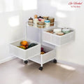 Go Hooked white 3-tiered rotating metal storage cart with perforated baskets holding fruits, vegetables, and jars.