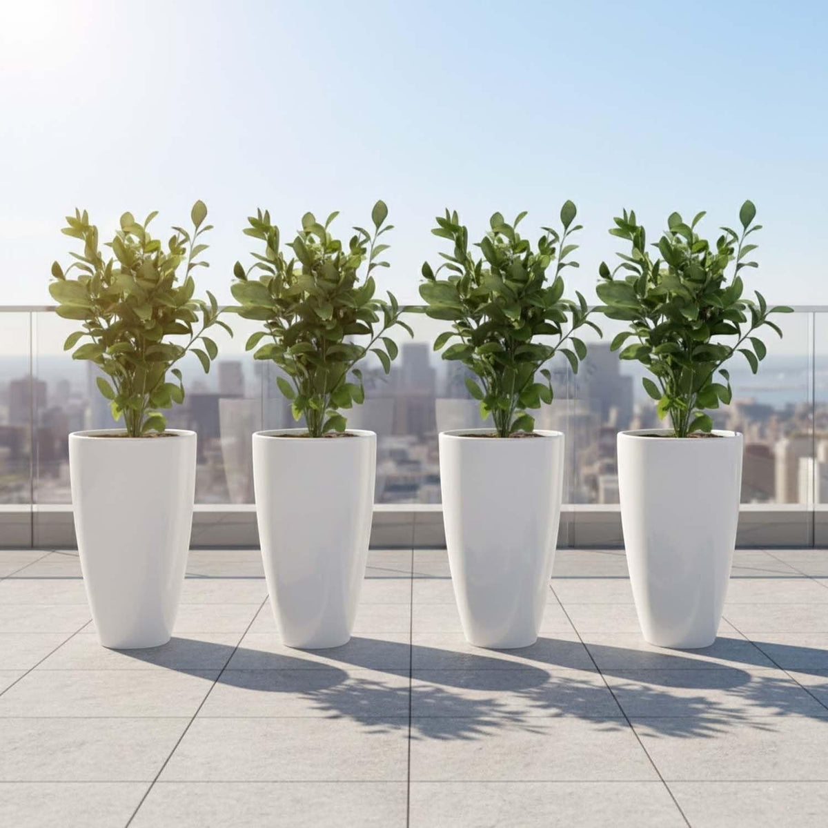 GoHooked white modern tall plastic planters with drainage holes, set of 5, on a balcony with city view.