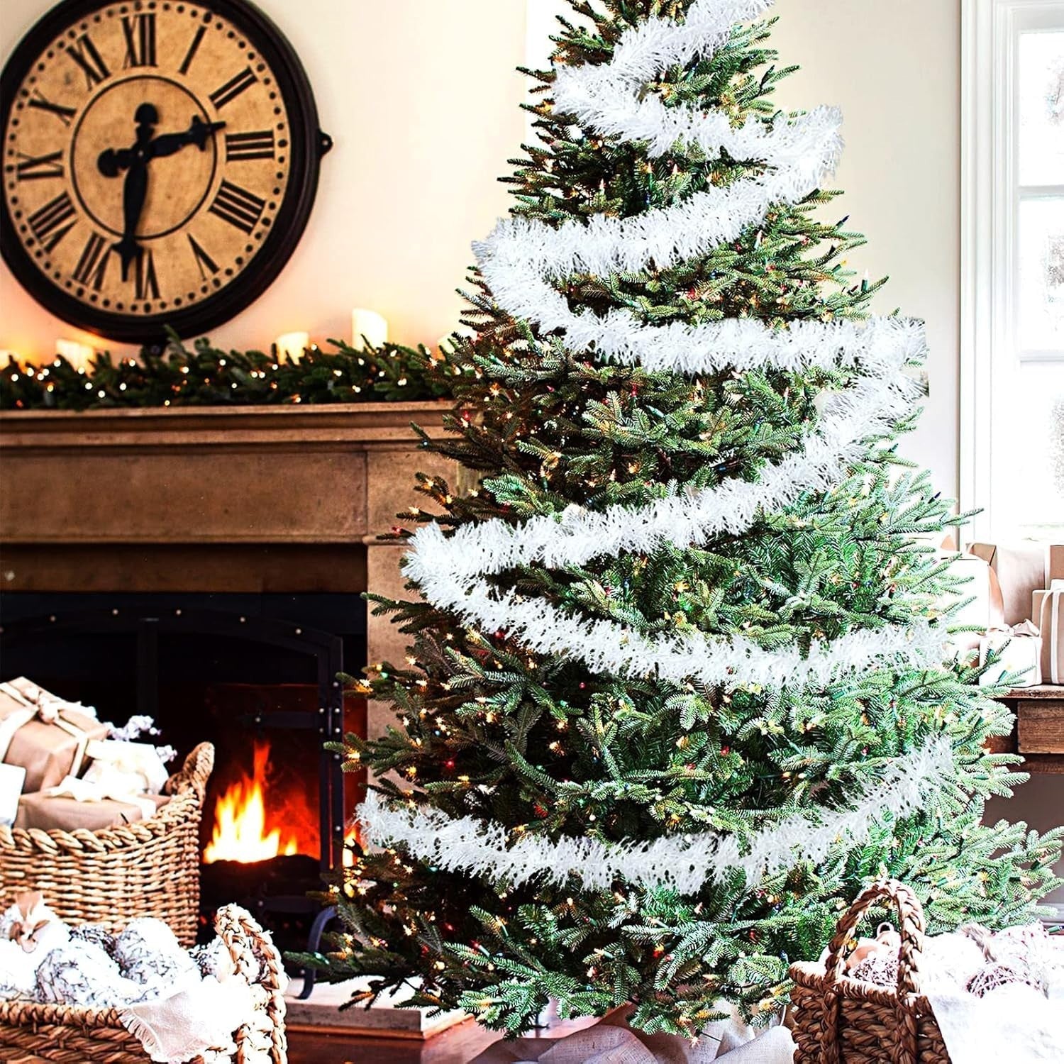 Go Hooked 3-piece snow white tinsel garland draped on a Christmas tree with a fireplace and clock in the background.