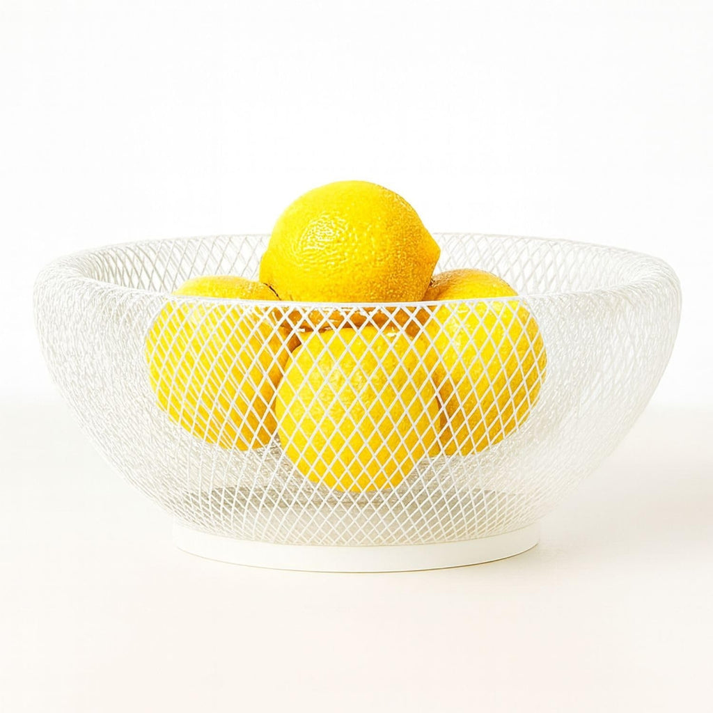 Go Hooked white wire fruit basket with diamond pattern, holding fresh lemons. Decorative and functional.