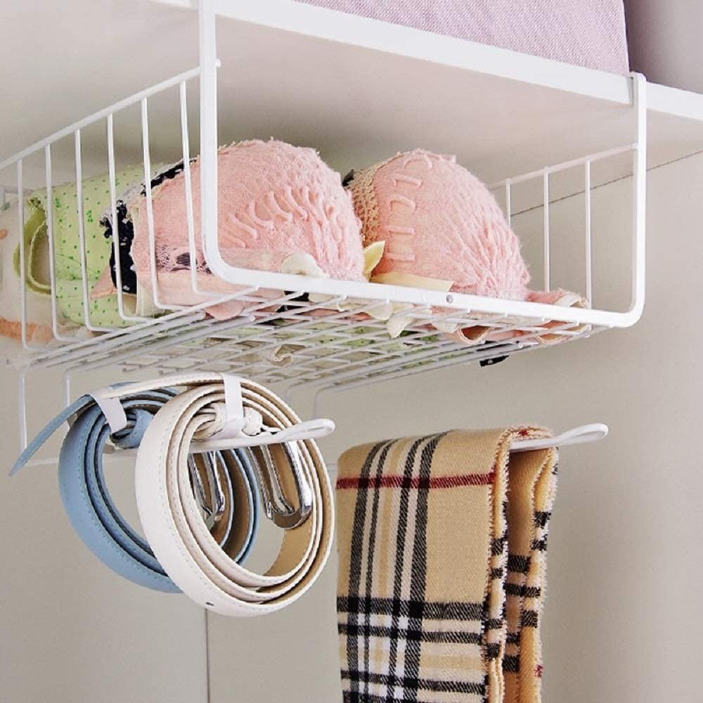 GoHooked white wire under-cabinet storage basket with two shelves, holding bras and accessories. Includes hooks for belts and a scarf.