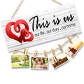 GoHooked white MDF wood wall sign with "This is us our life . our story . our home" text and red hearts, holding photos with clips.