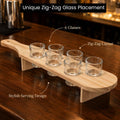 GoHooked wooden shot glass serving paddle with six clear glasses arranged in a stylish zig-zag layout on a table.
