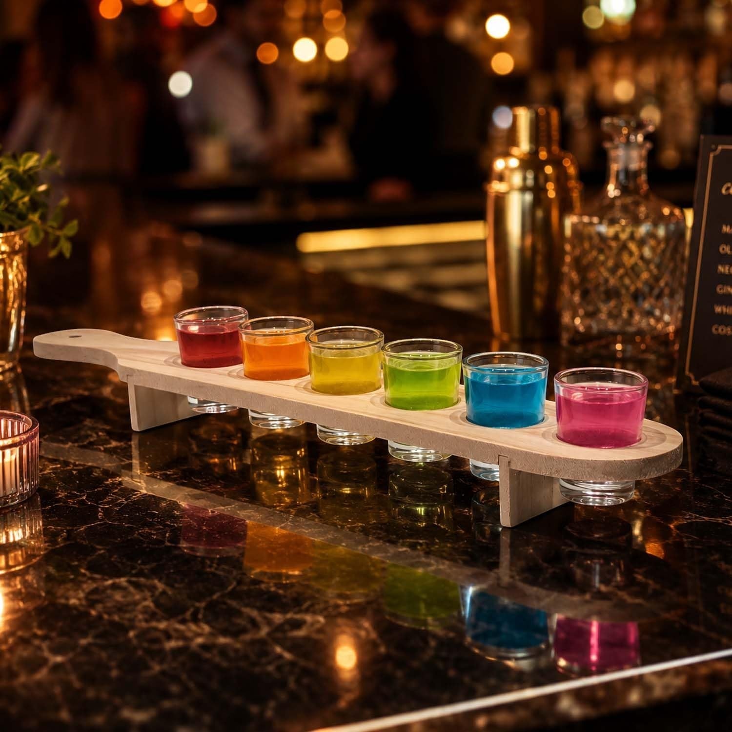 GoHooked wooden shot glass paddle set with six colorful drinks in clear glasses on a dark bar counter.