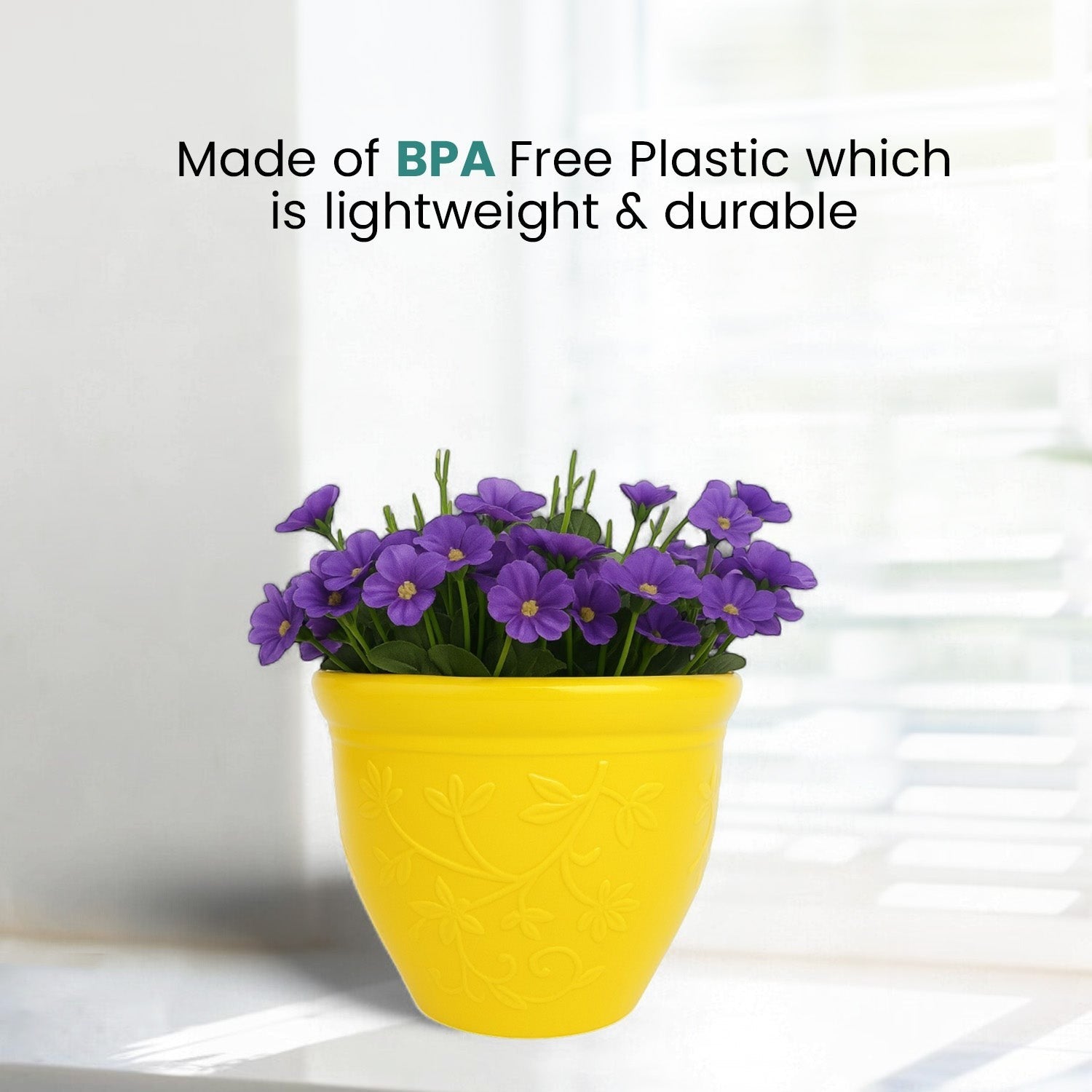 GoHooked yellow plastic planter pot with embossed floral pattern holding purple flowers on a bright windowsill