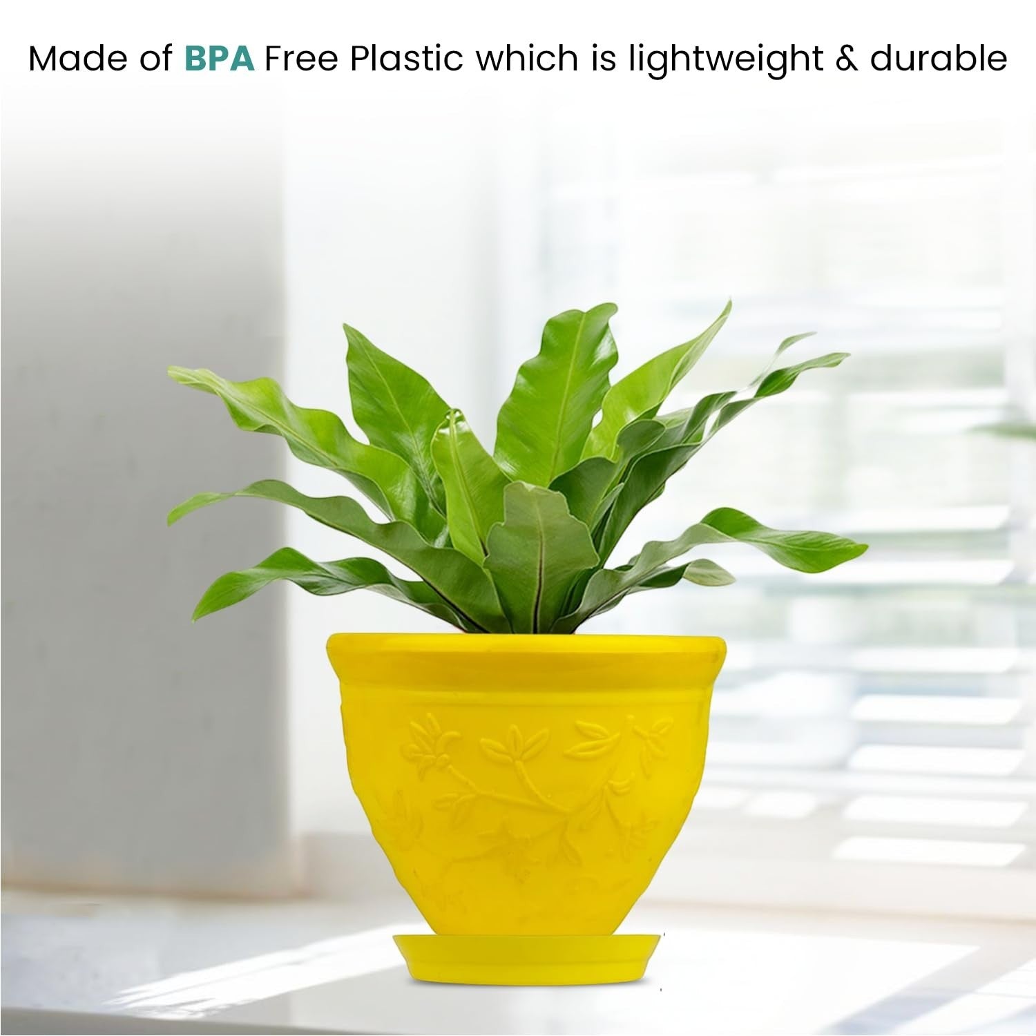 Go Hooked yellow plastic planter pot with embossed floral design and matching saucer, holding a green plant.