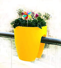 GoHooked yellow plastic railing planter with flowers and a colorful pinwheel decoration.