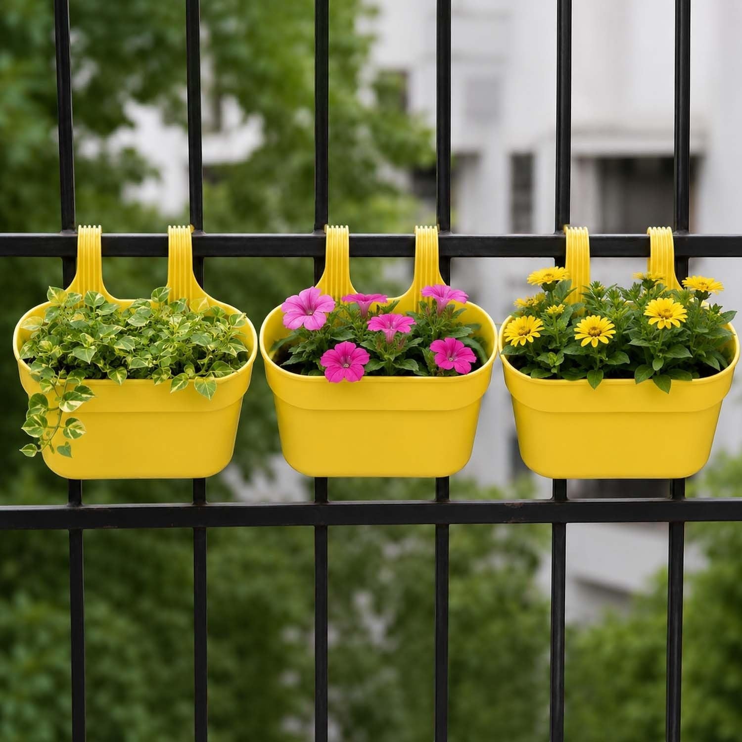 GoHooked set of 3 yellow plastic railing hanging planters with double hooks, holding green plants, pink flowers, and yellow flowers.