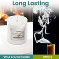 ViMe white glass jar candle with lasting lily scent, burning beside a fireplace.